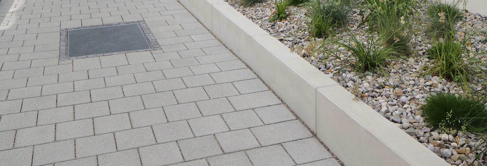 Beton-Bordelemente zur Abgrenzung von Kiesbeeten und Gehwegflächen
