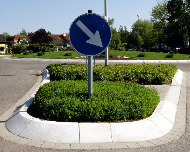 Verkehrsinsel mit Flachbordsteinen zur klaren Abgrenzung von Fahrbahn und Grünfläche