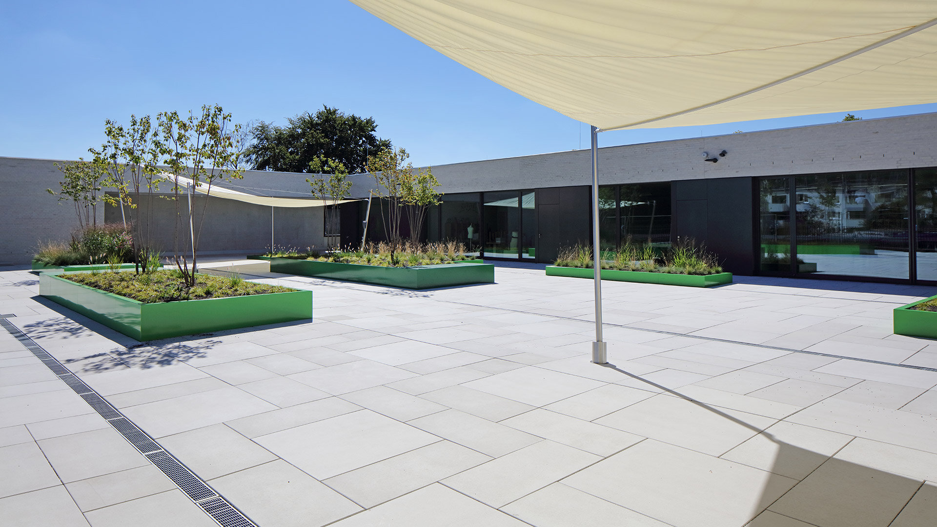 Moderner begrünter Innenhof mit großformatigen Titania Terrassenplatten