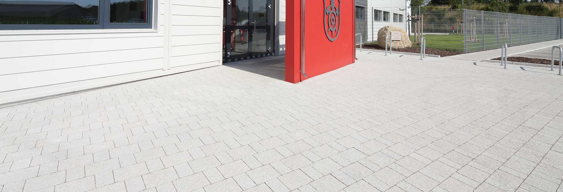 Helle Pflasterfläche mit Trento Bianco Steinen für moderne Außenanlagen