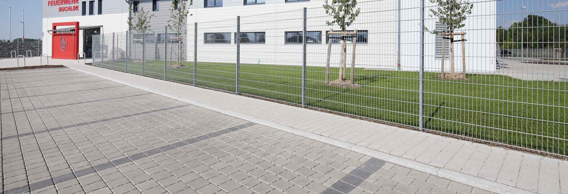 Versickerungsfähige Verkehrsfläche vor einem modernen Bürokomplex