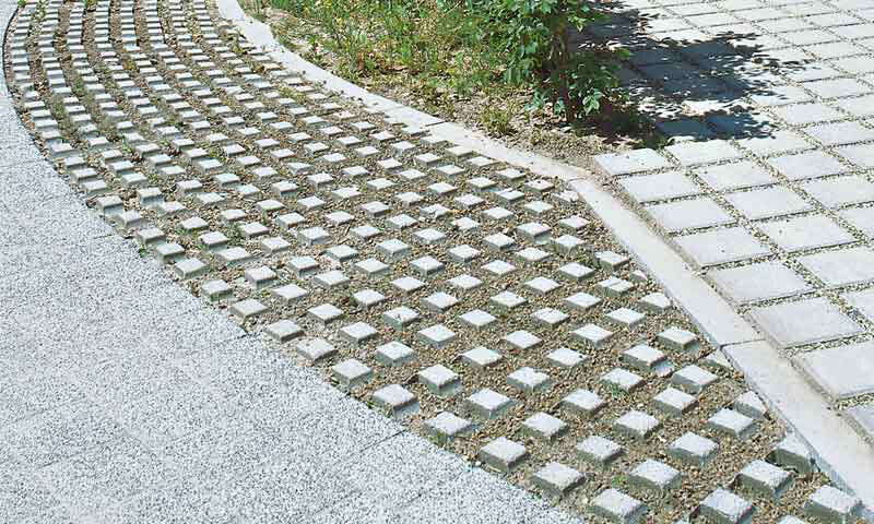 Begrünbare BG-Platten entlang eines Fahrbahnrandes mit angrenzendem Gehweg