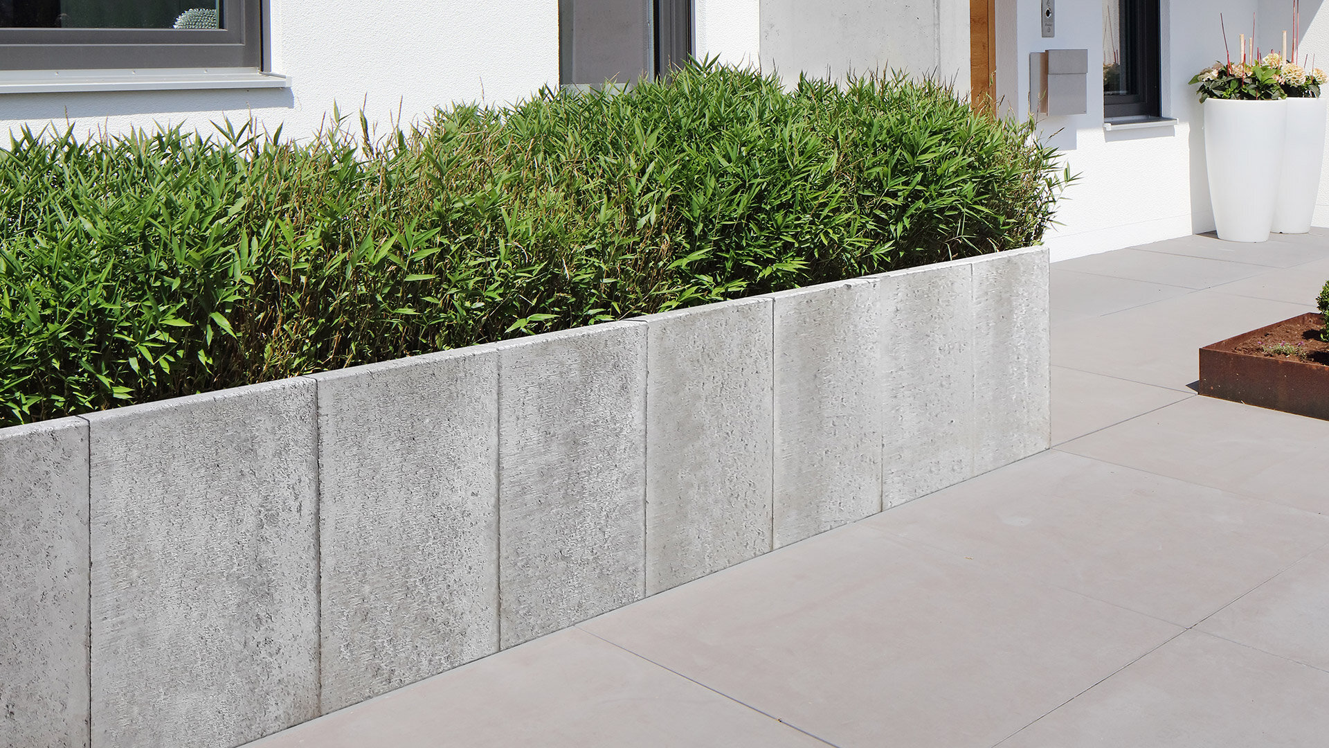 Slider Bild eines Gartens mit L Steine Haus