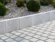 Ansicht eines Gartens mit L Stein grau Beet